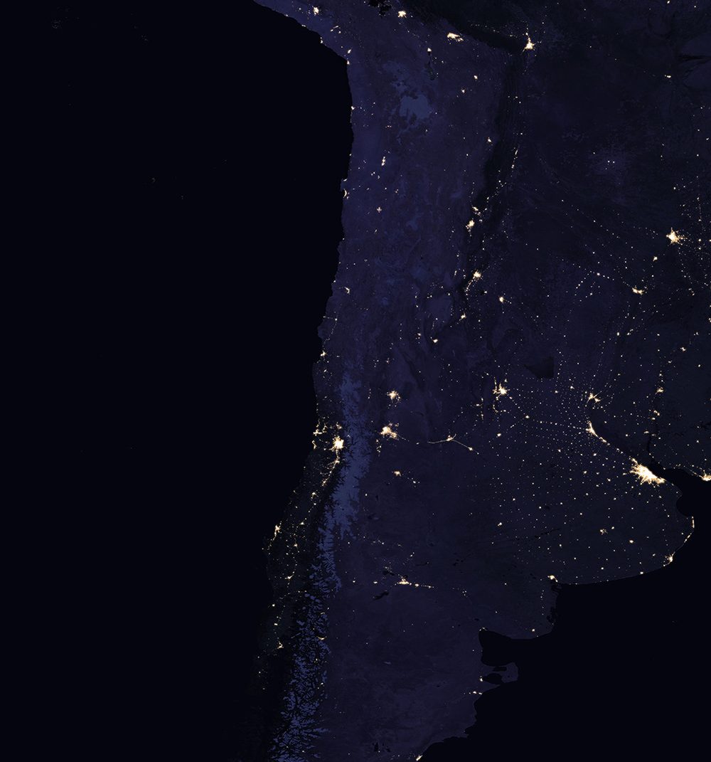 South America at night from space: the lights of cities and power grids across Chile and Argentina.